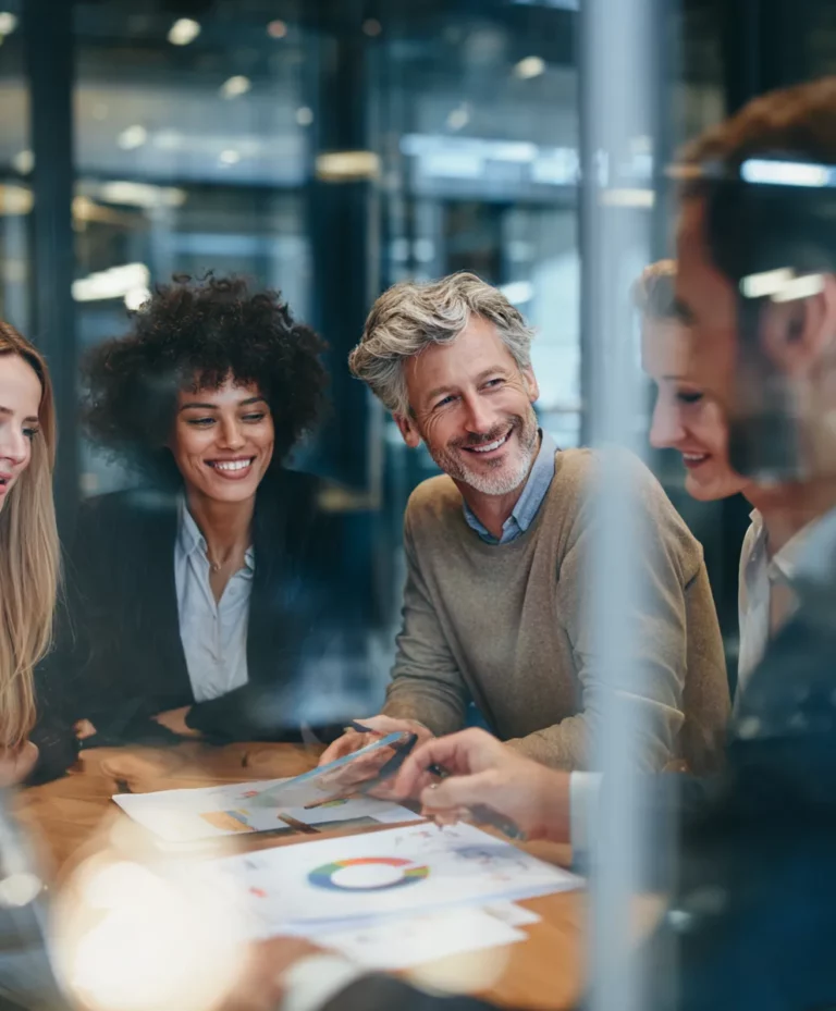 Équipe associative en réunion de travail préparant un budget prévisionnel, subventions et mécénat