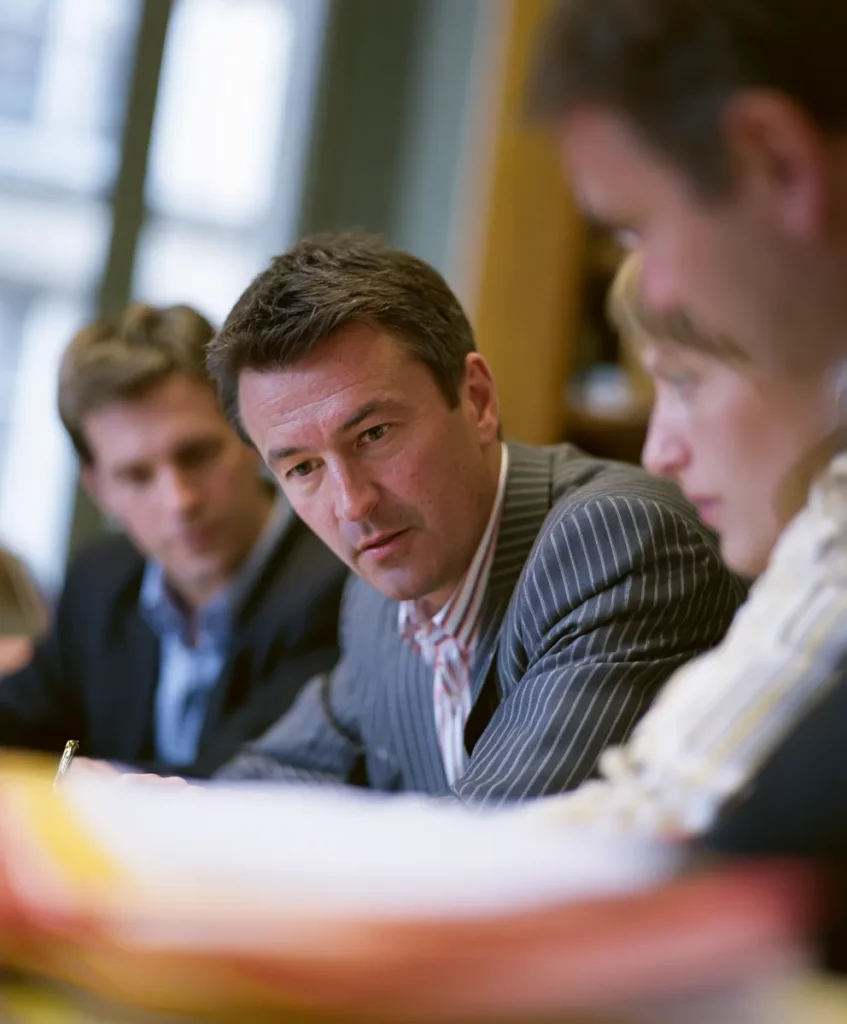 Repreneur et auditeurs examinant les comptes d'une PME cible lors d'une due diligence