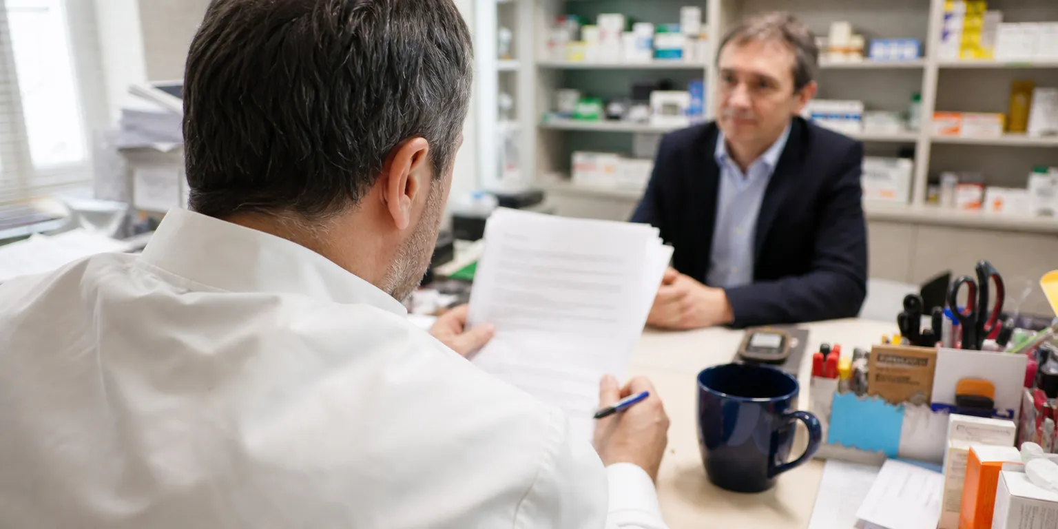 Titulaire d'officine relisant un accord de remises avec un laboratoire de génériques