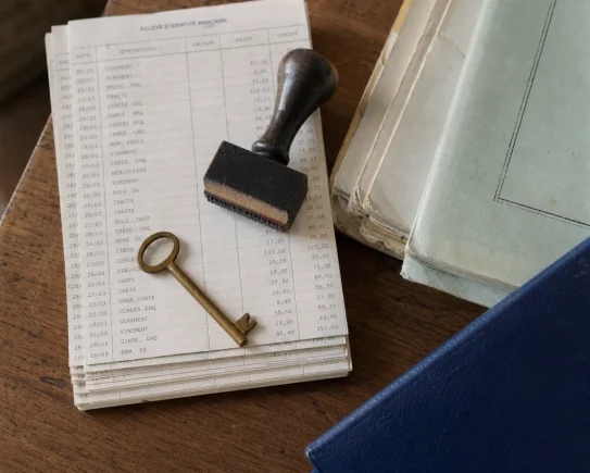Clés et relevés bancaires posés sur un comptoir, symbole de la clôture d'un compte professionnel