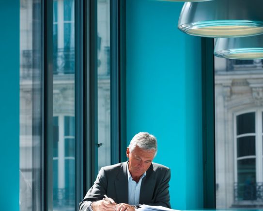 Expert-comptable analysant des documents de cotisations sociales dans un bureau moderne