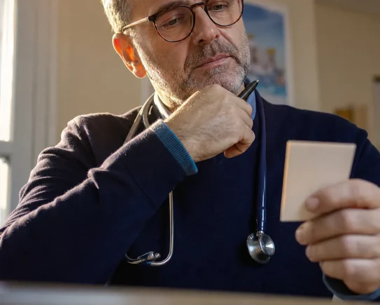 Médecin généraliste pensif dans son cabinet face à la revalorisation de la consultation médecin en 2026