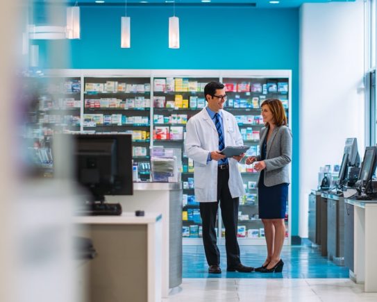 Pharmacien et préparateur discutant des nouvelles classifications en officine